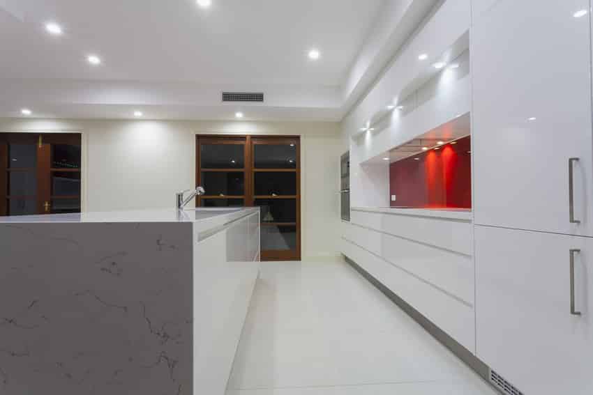 Double line kitchen in white with red accent back splash