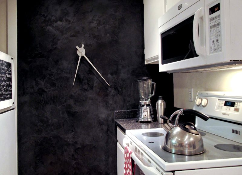Дизайнерские часы на темной стене небольшой кухни