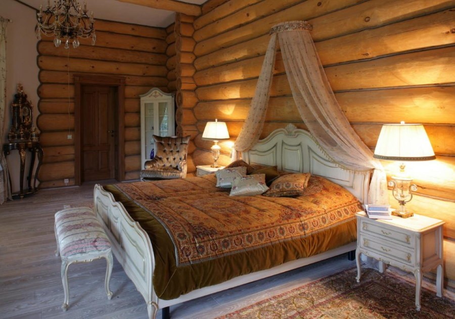 Широкая кровать в спальне бревенчатого дома