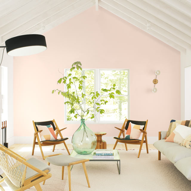 A casual living room with a light pink-painted accent wall