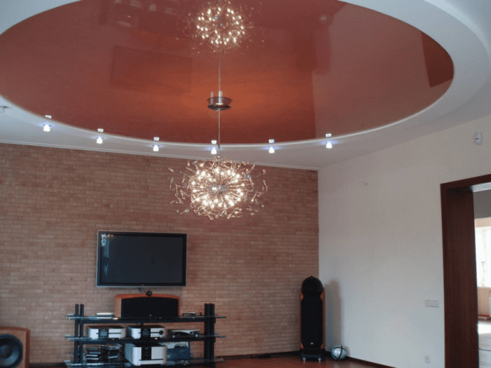 Дизайн натяжного потолка яркого цвета и необычной формы для гостиной